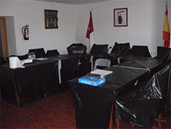 Mesa de Sal&oacute;n de Plenos cubierta con pl&aacute;sticos negros para evitar ara&ntilde;azos en la madera y la acumulaci&oacute;n de polvo.
