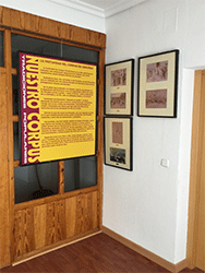 Panel explicativo del Corpus Christi de Camu&ntilde;as y tres im&aacute;genes de la exposici&oacute;n entrando a la sala a la izquierda