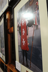 Detalle de la parte central de la exposici&oacute;n donde se ve en primer plano el "Pecado Mundo", de espaldas, mostrando su sereno rojo con las tres cruces de Malta blancas.  