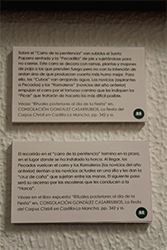 Detalle de las cartelas que explicaban las im&aacute;genes representadas en las fotograf&iacute;as de la exposici&oacute;n y las relacionaban con el libro "La Fiesta del Corpues Christi en Castilla-La Mancha" ubicado en un atril en el centro de la sala para su consulta por los visitantes