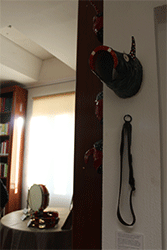 Detalle de la careta del "Pecado Mayor" o "Bocagorrino" y la correa. Al fondo, la mesa con los instrumentos musicales.