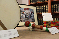 Detalle de los instrumentos musicales: tambor, porras y sonaja. Al fondo, la fotograf&iacute;a con la imagen donde aparecen los personajes del Corpus con estos instrumentos.